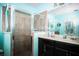 Bathroom with a tiled walk-in shower, dual sinks, and black cabinets at 4793 Grassy Knoll Dr, Tavares, FL 32778