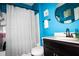 Stylish bathroom with blue walls, a dark vanity, and a shower-tub combination with a patterned shower curtain at 4793 Grassy Knoll Dr, Tavares, FL 32778