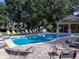 Serene community pool with inviting lounge chairs and shaded pavilion surrounded by mature trees, offering relaxation at 4793 Grassy Knoll Dr, Tavares, FL 32778