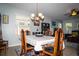Elegant dining room with a chandelier, classic wooden chairs, and a table set for a comfortable meal at 4793 Grassy Knoll Dr, Tavares, FL 32778
