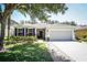 Charming home featuring manicured lawn, colorful shrubs, and a two-car garage at 4793 Grassy Knoll Dr, Tavares, FL 32778