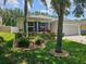 Lovely single-story home boasts mature landscaping, blue shutters, and a two-car attached garage at 4793 Grassy Knoll Dr, Tavares, FL 32778