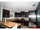 A spacious kitchen featuring dark wood cabinets, stainless steel appliances, and a peninsula bar at 4793 Grassy Knoll Dr, Tavares, FL 32778