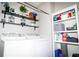 Functional laundry room with a washer and dryer, shelving for storage, and stylish decorative accents at 4793 Grassy Knoll Dr, Tavares, FL 32778