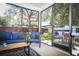 Screened-in porch with comfortable blue seating, offering an inviting outdoor living space at 4793 Grassy Knoll Dr, Tavares, FL 32778