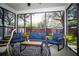 Cozy screened porch featuring blue furniture, decorative rug, and views of the surrounding greenery at 4793 Grassy Knoll Dr, Tavares, FL 32778
