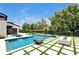 Modern backyard with a sparkling pool, stylish patio, and lush green landscaping at 5525 Isleworth Country Club Dr, Windermere, FL 34786