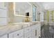 Bathroom featuring marble countertops, patterned tile floors, and an illuminated mirror at 5525 Isleworth Country Club Dr, Windermere, FL 34786