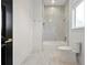 Bright bathroom features tile flooring, soaking tub, toilet and marble-tiled shower with glass enclosure at 5525 Isleworth Country Club Dr, Windermere, FL 34786