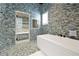 Stylish bathroom featuring mosaic tile, glass enclosed shower and a free-standing soaking tub at 5525 Isleworth Country Club Dr, Windermere, FL 34786