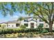 A beautiful, modern home with manicured landscaping and a stately, mature tree providing shade and character at 5525 Isleworth Country Club Dr, Windermere, FL 34786