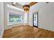 Living room with large windows, a modern chandelier, and hardwood floors at 5525 Isleworth Country Club Dr, Windermere, FL 34786