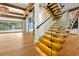 Elegant living room featuring a glass staircase, fireplace, and ample natural light at 5525 Isleworth Country Club Dr, Windermere, FL 34786