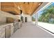 Outdoor kitchen with stainless steel appliances and clear view of the pool at 5525 Isleworth Country Club Dr, Windermere, FL 34786