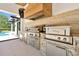 Luxurious outdoor kitchen featuring stone counters, stainless steel appliances, and custom hood, perfect for entertaining at 5525 Isleworth Country Club Dr, Windermere, FL 34786