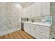 Wet bar area featuring white cabinetry, mirrored backsplash, wine fridge, and quartz countertops at 5525 Isleworth Country Club Dr, Windermere, FL 34786