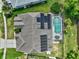 Aerial view of home featuring a screened pool, solar panels, and a well-maintained lawn at 633 Lakehaven Cir, Orlando, FL 32828