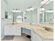 Bright bathroom offers double sinks, white cabinets and great lighting at 633 Lakehaven Cir, Orlando, FL 32828