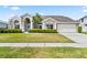 Charming single-Gathering home featuring a well-manicured lawn and a light blue front door with decorative wreath at 633 Lakehaven Cir, Orlando, FL 32828