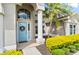 Close-up of the front door with a blue finish and a decorative wreath, complemented by manicured landscaping at 633 Lakehaven Cir, Orlando, FL 32828