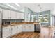 Well-lit kitchen boasts white cabinetry, granite countertops, stainless steel appliances, and a breakfast nook at 633 Lakehaven Cir, Orlando, FL 32828