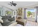 Spacious living room with views of the pool and backyard, featuring a gray sectional and a decorative plant at 633 Lakehaven Cir, Orlando, FL 32828