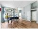 Bright living room with wood floors, a grand piano, and large windows providing ample natural light at 633 Lakehaven Cir, Orlando, FL 32828