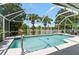 Relaxing screened pool area with spa and tranquil lake views with palm trees for the perfect private backyard at 633 Lakehaven Cir, Orlando, FL 32828