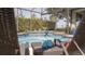 Relaxing screened-in pool with waterfall feature, complemented by comfortable lounge chairs and serene backyard views at 6350 Sedona Leaf Ct, Windermere, FL 34786