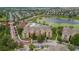 Aerial view shows condo complex with many buildings, pool, parking and pond at 7650 Comrow St # 403, Kissimmee, FL 34747
