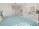 Bright bedroom with a turquoise quilt, white dresser, and a large mirror, offering a serene retreat at 7650 Comrow St # 403, Kissimmee, FL 34747