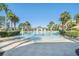 Expansive community pool with a splash pad, surrounded by palm trees and lush landscaping at 7650 Comrow St # 403, Kissimmee, FL 34747