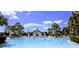 Resort-style swimming pool and splashpad area lined with lounge chairs and shaded by palm trees at 7650 Comrow St # 403, Kissimmee, FL 34747