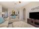 A cozy living room with arched doorways, comfortable seating, and a modern entertainment center at 7650 Comrow St # 403, Kissimmee, FL 34747