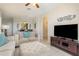 Comfortable living room featuring a large flat-screen TV, plush seating, and an open archway at 7650 Comrow St # 403, Kissimmee, FL 34747