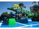 Modern water park featuring blue and green water slides with a bright green surface, surrounded by tropical landscaping at 7650 Comrow St # 403, Kissimmee, FL 34747