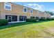 Lush backyard showcasing a row of townhomes with screened patios and well-maintained landscaping at 774 Chelsea Dr, Davenport, FL 33897