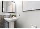 Bathroom featuring a pedestal sink with a modern mirror and decorative mosaic tile backsplash at 774 Chelsea Dr, Davenport, FL 33897