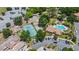 Aerial view of the community pool, tennis court, and parking areas surrounded by trees and greenery at 7768 Sugar Bend Dr # 7768, Orlando, FL 32819