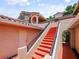 Exterior view of the home showcasing its red tiled roof and painted staircase at 7768 Sugar Bend Dr # 7768, Orlando, FL 32819