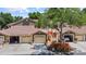 Inviting home exterior with attached garages, well-maintained landscaping, and tile roof at 7768 Sugar Bend Dr # 7768, Orlando, FL 32819