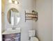 Bright bathroom with a dark wood vanity, oval mirror, and decorative shelf at 7819 Hardenton St, Windermere, FL 34786