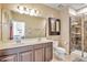 Bathroom featuring double sinks, a tiled shower, and a medicine cabinet at 7819 Hardenton St, Windermere, FL 34786