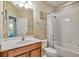 Bathroom with a cherry wood vanity, sink, and bathtub at 7819 Hardenton St, Windermere, FL 34786