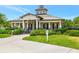 Community clubhouse featuring a unique architectural design, lush landscaping, and ample parking at 7819 Hardenton St, Windermere, FL 34786
