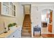 Bright home foyer with staircase, window, adjacent kitchen, and a tiled floor leading to the upper levels of the house at 7819 Hardenton St, Windermere, FL 34786