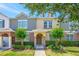 Inviting townhome with a well manicured lawn and a charming entryway with a decorated front door and green bushes at 7819 Hardenton St, Windermere, FL 34786