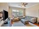 Comfortable living room with large windows, a cozy sectional sofa, and a ceiling fan for added comfort at 7819 Hardenton St, Windermere, FL 34786