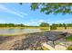 Scenic pond in a residential community with a walking path, park bench, and lush green grass at 7819 Hardenton St, Windermere, FL 34786