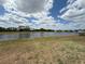 Wide, tranquil lake view from the backyard with cloudy sky at 786 Crystal Bay Ln, Orlando, FL 32828